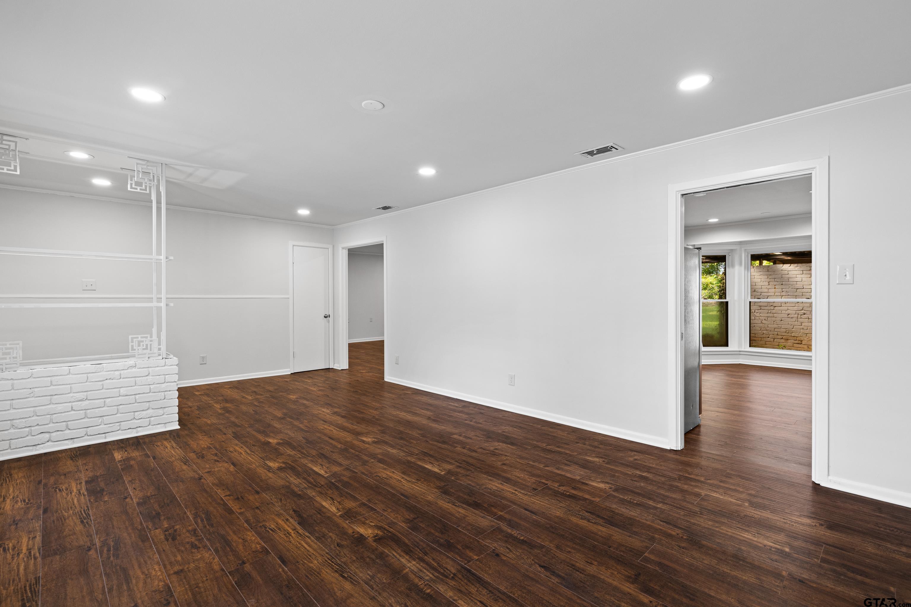 7 Lindsey Lane Longview, TX 75601 - Photo 8 of 36 a view of an empty room with wooden floor and a window