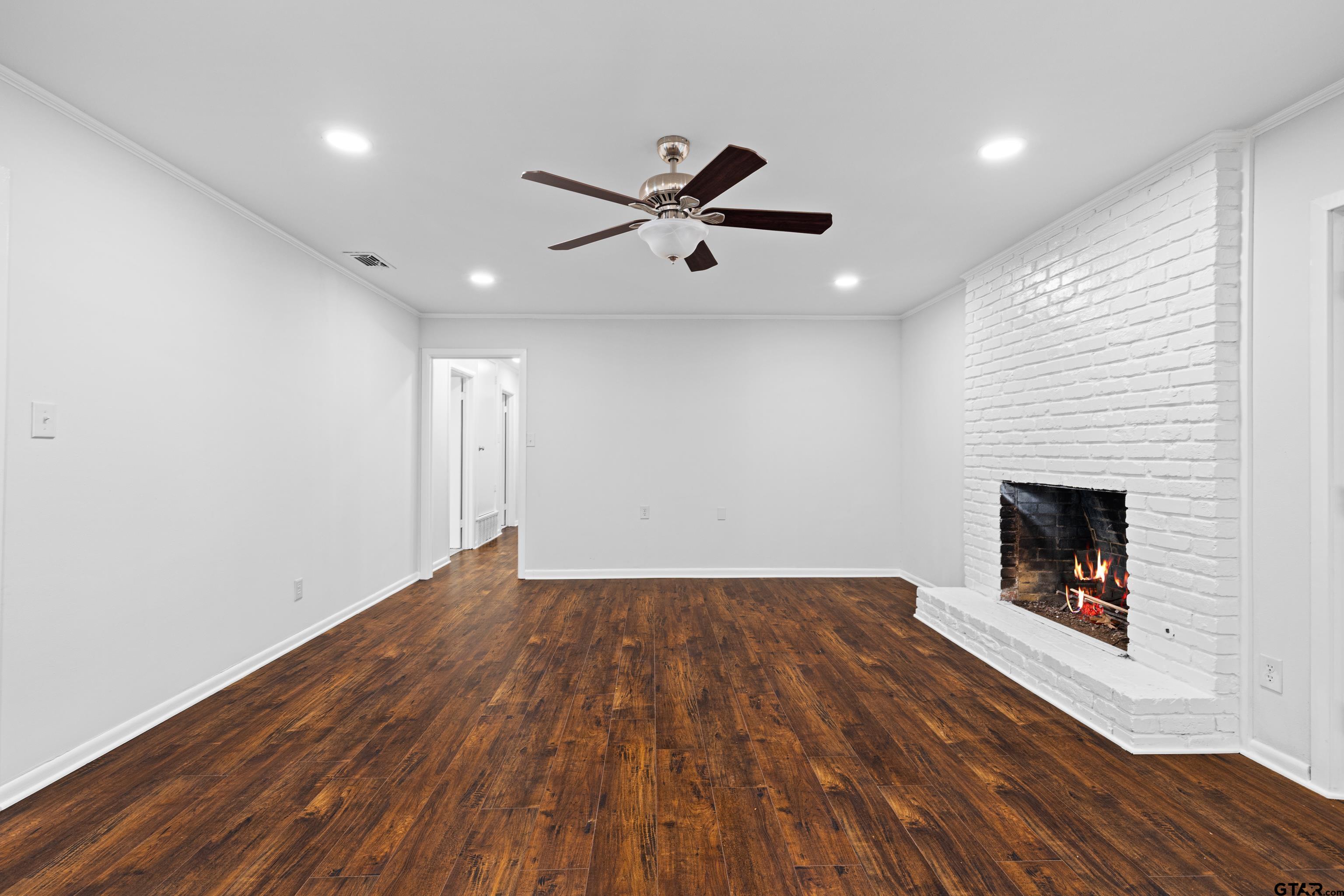 7 Lindsey Lane Longview, TX 75601 - Photo 10 of 36 a view of an empty room with wooden floor a fireplace and a window