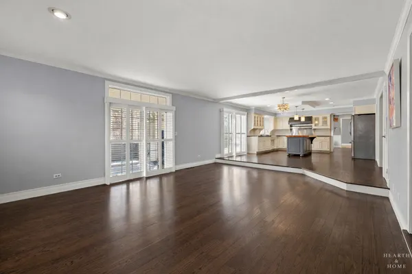 a view of empty room with wooden floor and windows