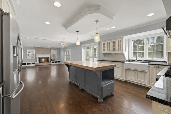 a large kitchen with stainless steel appliances a large counter top a stove a chimney a sink and a large window