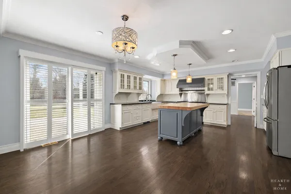 a kitchen with stainless steel appliances kitchen island wooden floors and center island