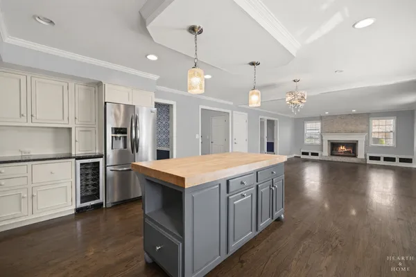 a kitchen with kitchen island a stove a sink a refrigerator and a counter top space