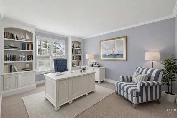 a living room with furniture and a potted plant on the dresser