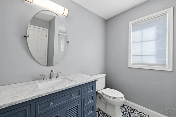 a bathroom with a toilet a sink and mirror