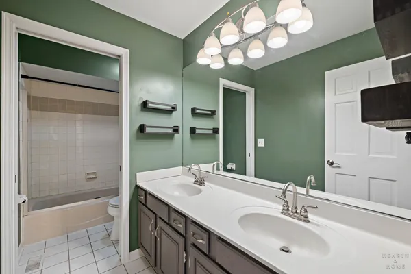 a bathroom with a sink a toilet and a large mirror