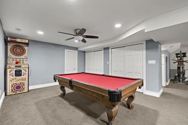 a room with pool table and a ceiling fan