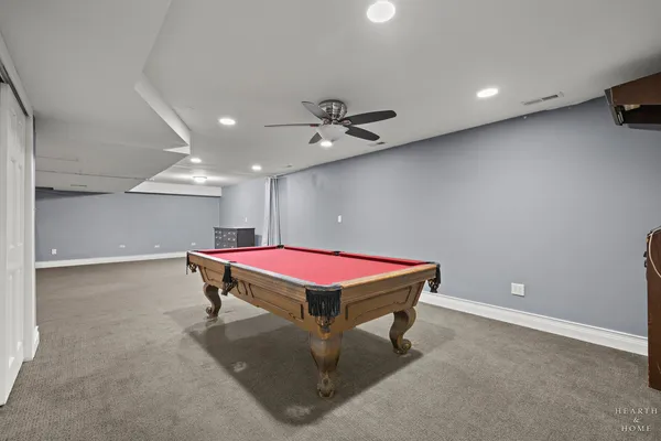 a room with table tennis table and a ceiling fan