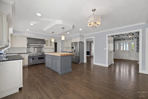 a large kitchen with a center island stainless steel appliances and wooden floor