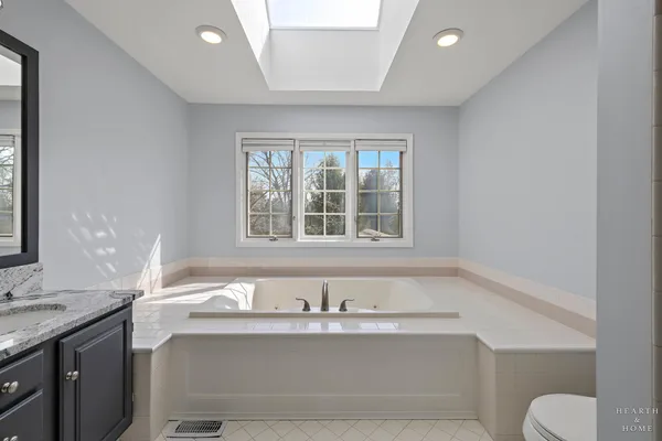 a bathroom with a granite countertop sink mirror vanity and toilet