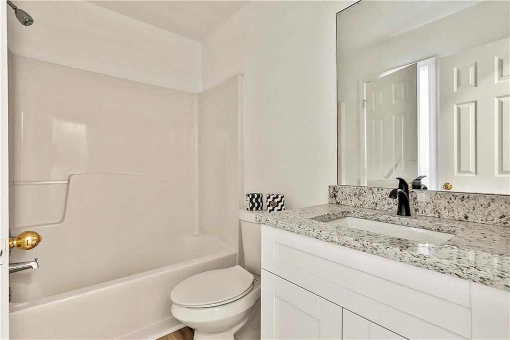 4605 Raven Wood Loop Union City, GA 30291 - Photo 6 of 24 a bathroom with a granite countertop sink a toilet and bathtub