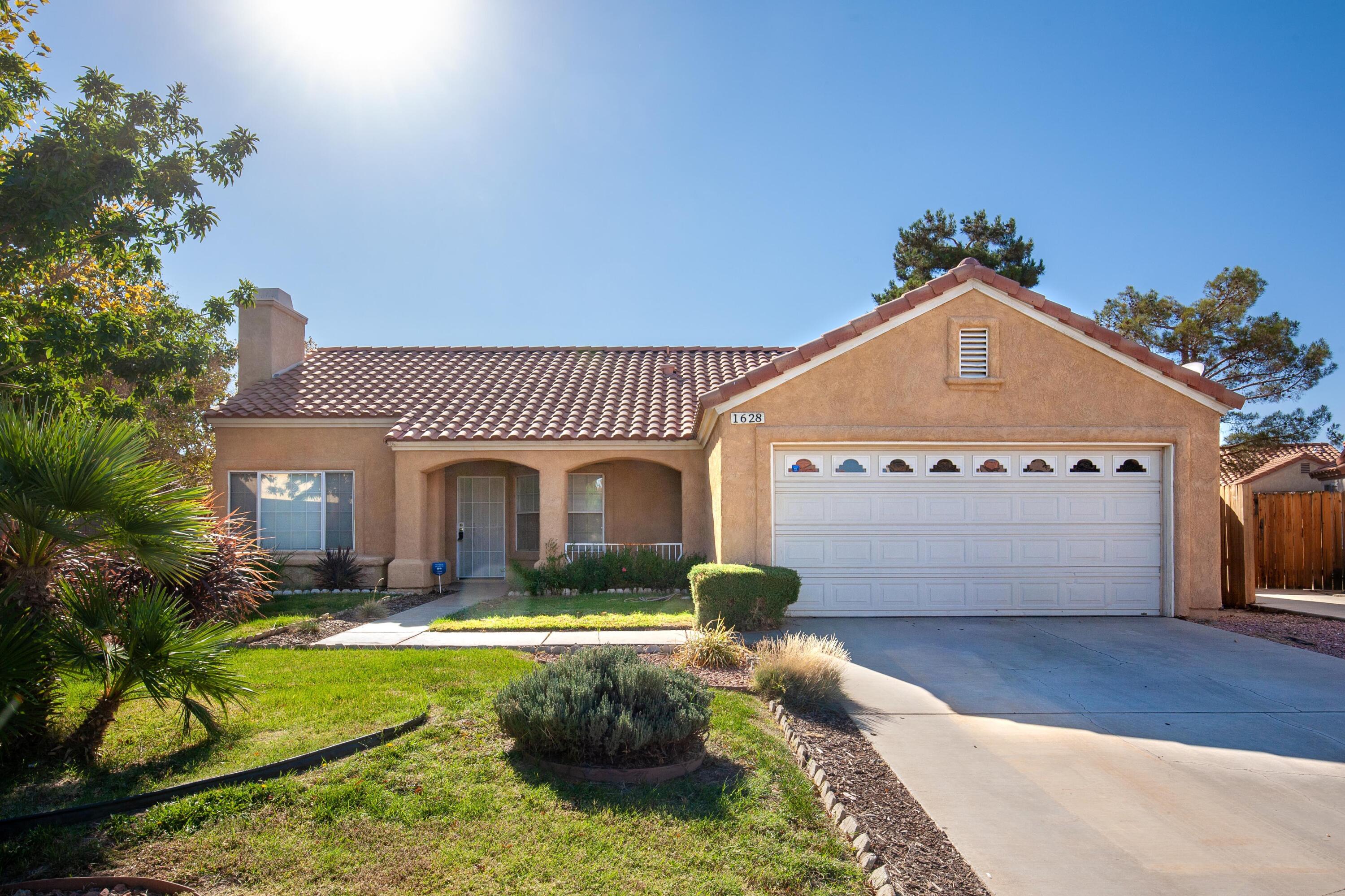 1628 Kings Road Palmdale, CA 93551 - Photo 1 of 22 a front view of a house with garden