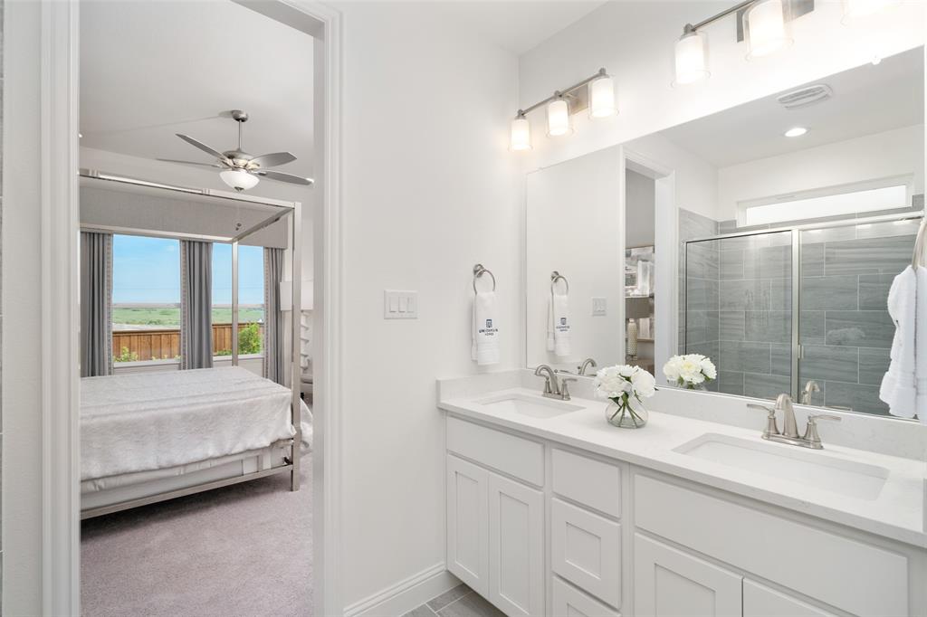 117 Pintail Lane Rhome, TX 76078 - Photo 16 of 29 a en suite bathroom with a double vanity sink a mirror and a bathtub