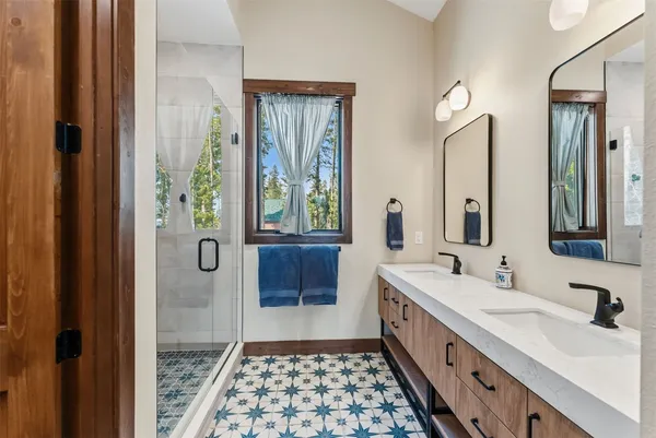 a bathroom with a double vanity sink a mirror and a shower