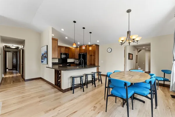 a kitchen with a dining table chairs and wooden floor