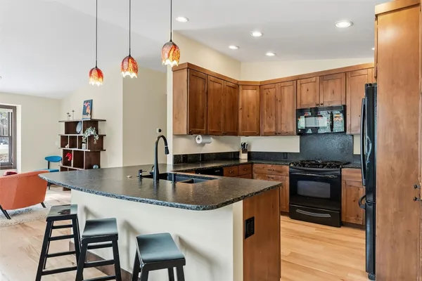 a kitchen with stainless steel appliances granite countertop a sink stove and refrigerator