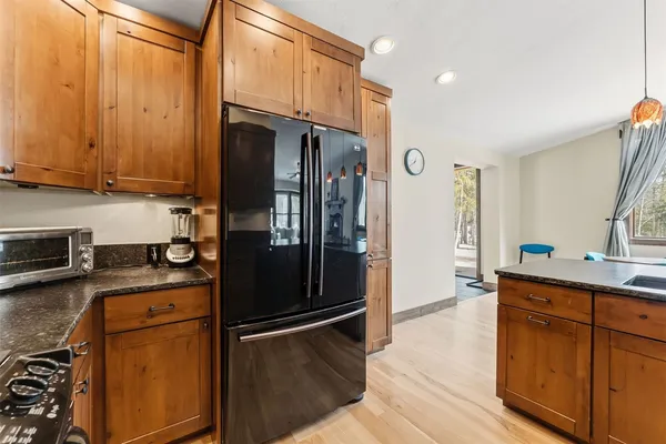 a kitchen with granite countertop a refrigerator stove and sink