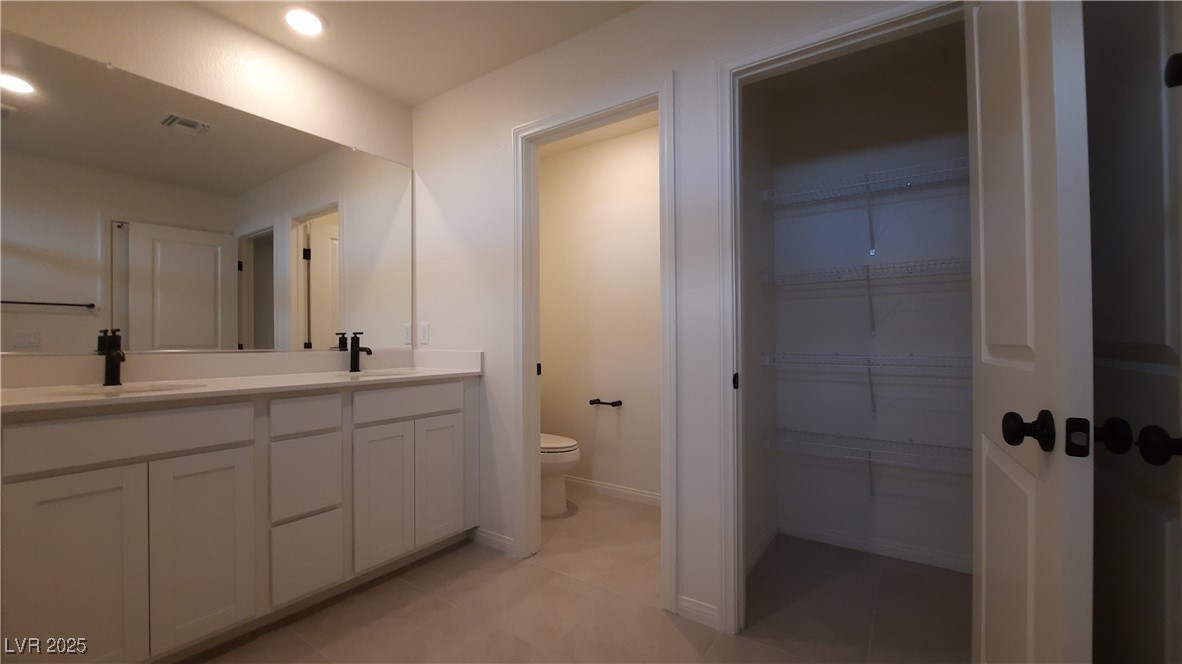 9084 Marigold Crk Street Las Vegas, NV 89113 - Photo 9 of 17 Full bath featuring double vanity, a spacious closet, light tile patterned flooring, and recessed lighting