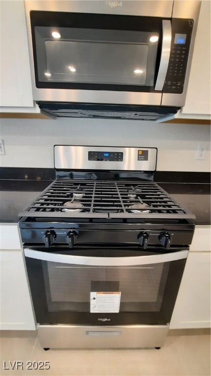 9084 Marigold Crk Street Las Vegas, NV 89113 - Photo 7 of 17 Kitchen view of stainless steel appliances, white cabinetry, and dark stone countertops