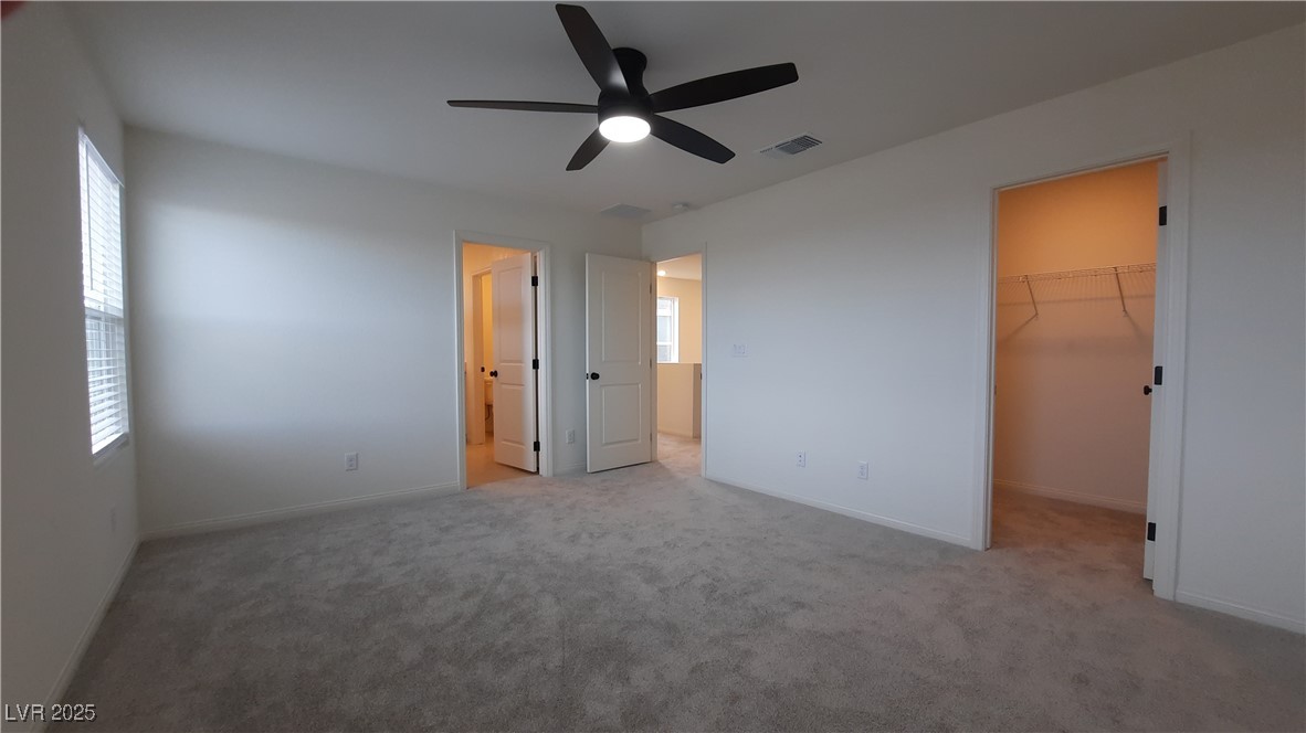 9084 Marigold Crk Street Las Vegas, NV 89113 - Photo 8 of 17 Unfurnished bedroom featuring carpet floors, a spacious closet, and ceiling fan