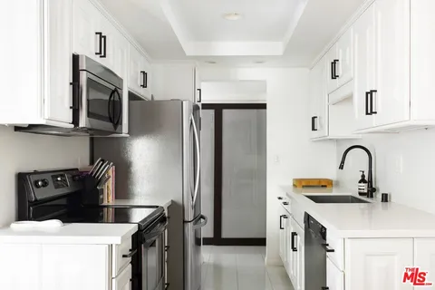 a kitchen with stainless steel appliances a refrigerator a sink a stove and dishwasher