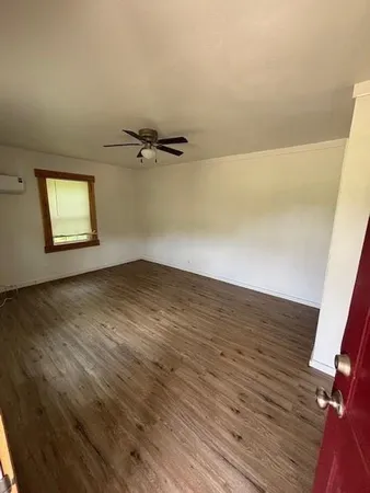 a view of a room with wooden floor and a window