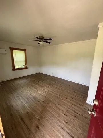 a view of a room with wooden floor and a window