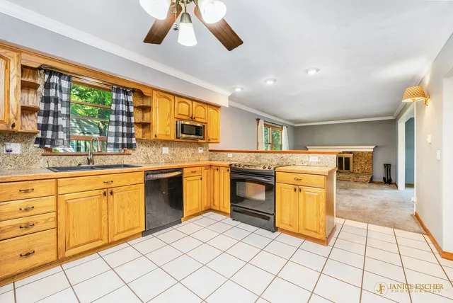 a kitchen with stainless steel appliances granite countertop a stove a sink and a microwave
