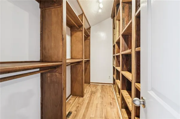 a view of walk in closet with empty racks