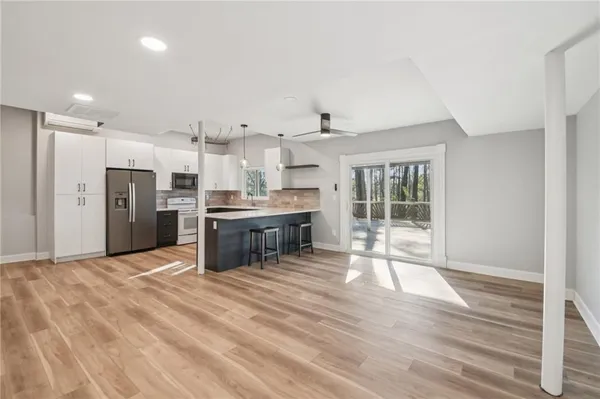 a open kitchen with stainless steel appliances kitchen island granite countertop a refrigerator and cabinets