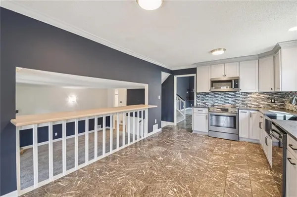 a kitchen with stainless steel appliances kitchen island granite countertop a stove a sink and a refrigerator
