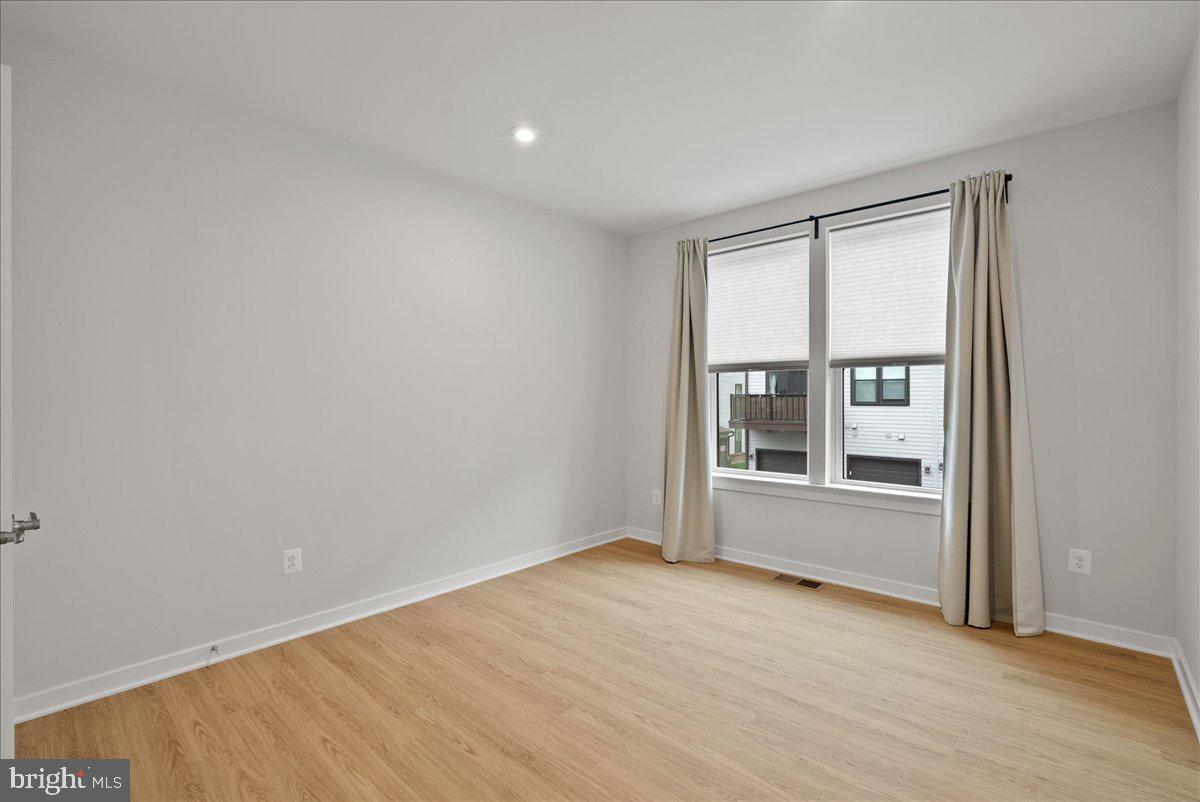 4128 Legato Road, Unit 53 Fairfax, VA 22033 - Photo 18 of 39 an empty room with wooden floor and windows