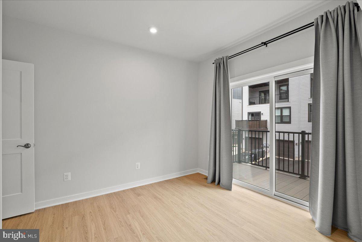 4128 Legato Road, Unit 53 Fairfax, VA 22033 - Photo 22 of 39 en empty room with sliding door and wooden floor