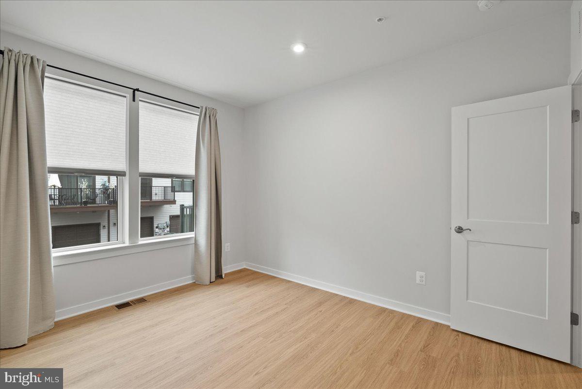 4128 Legato Road, Unit 53 Fairfax, VA 22033 - Photo 23 of 39 an empty room with wooden floor and windows