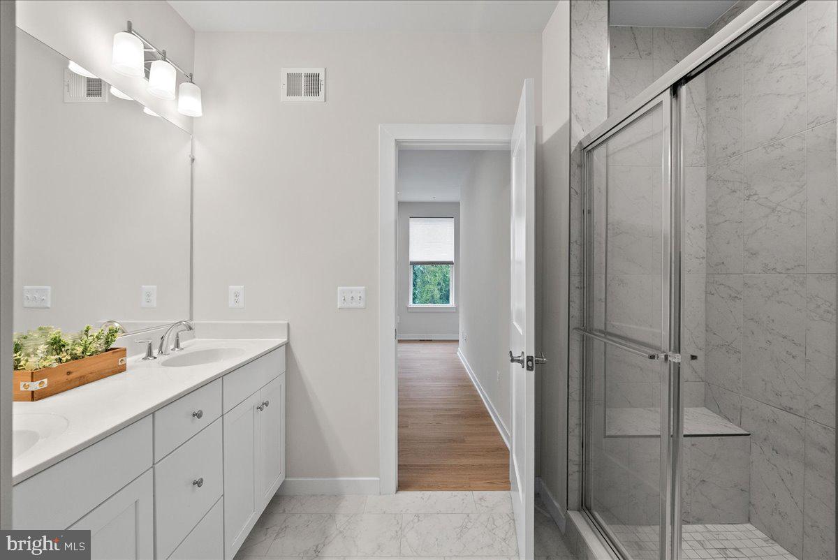 4128 Legato Road, Unit 53 Fairfax, VA 22033 - Photo 33 of 39 a bathroom with a double vanity sink and mirror