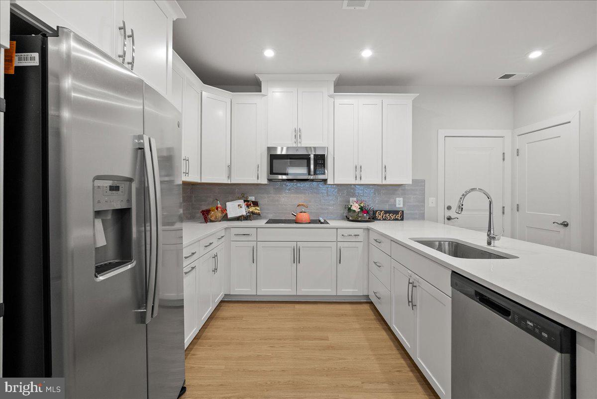 4128 Legato Road, Unit 53 Fairfax, VA 22033 - Photo 6 of 39 a kitchen with stainless steel appliances granite countertop a refrigerator sink and white cabinets
