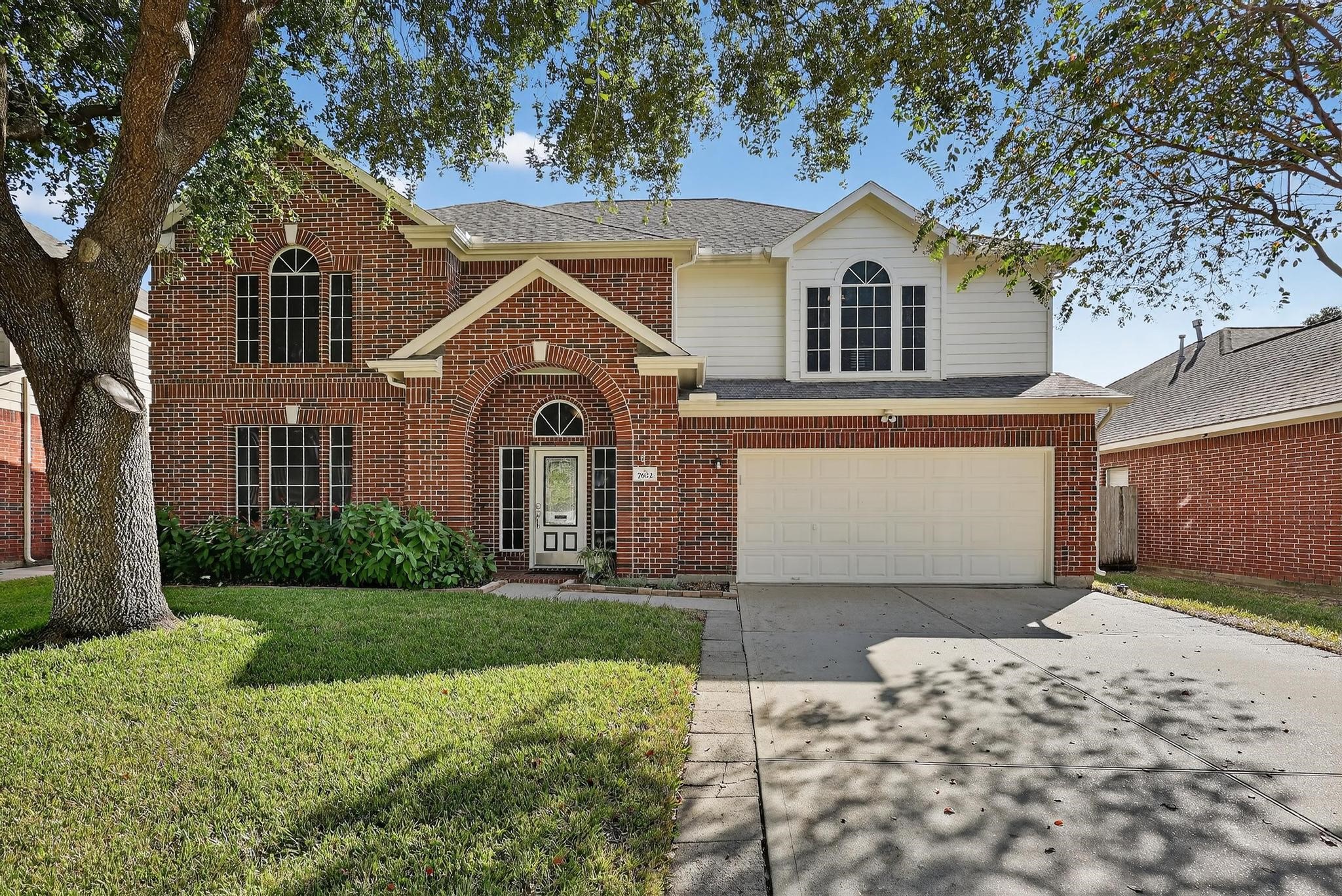 a front view of a house with a yard and garage