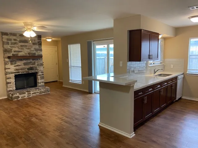 a kitchen with stainless steel appliances granite countertop a sink a stove and a wooden floors