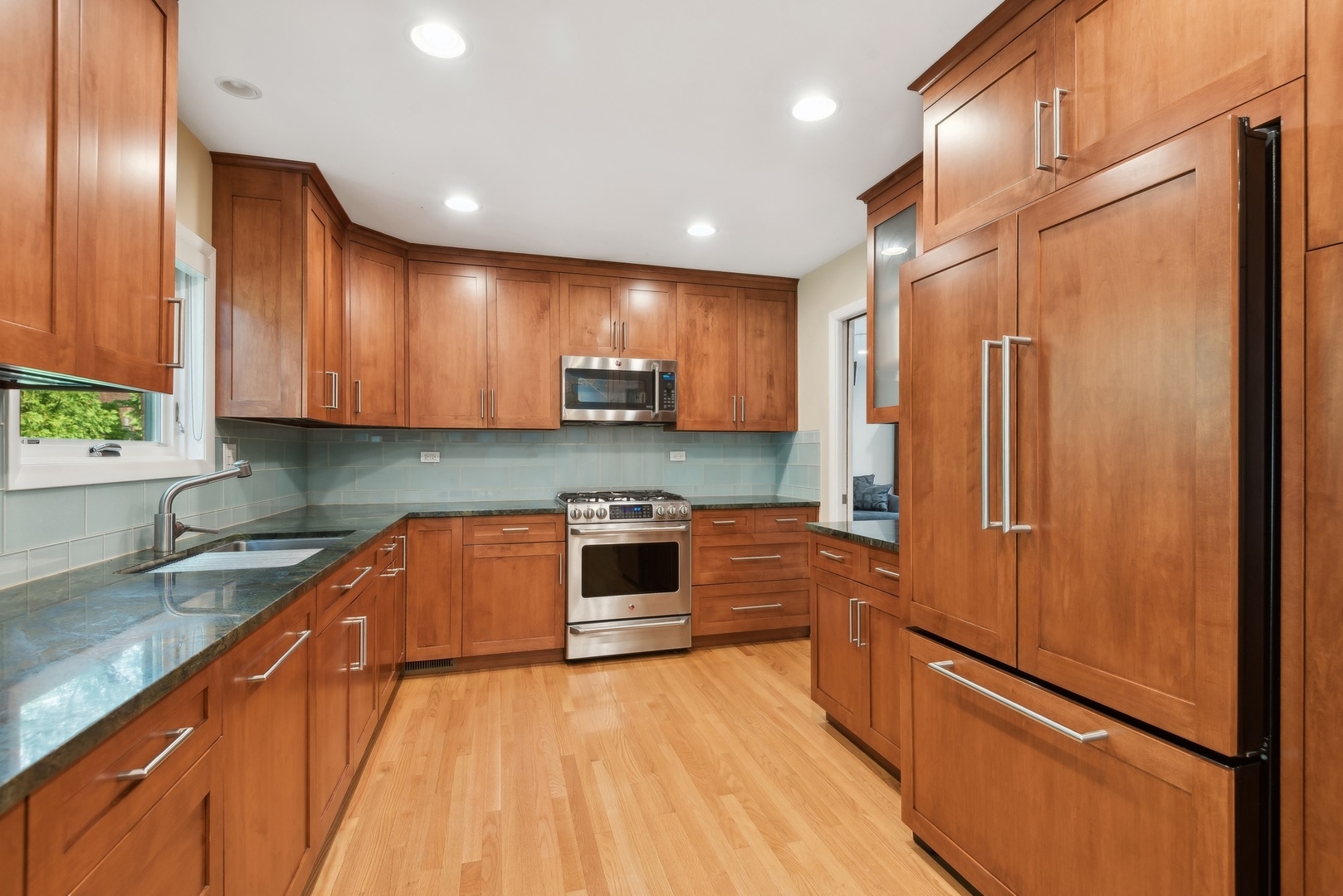 816 Echo Lane Glenview, IL 60025 - Photo 4 of 25 a kitchen with stainless steel appliances granite countertop a refrigerator a sink dishwasher a stove with wooden cabinets and floor