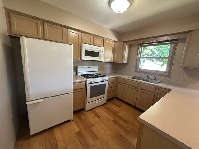 a kitchen with stainless steel appliances a refrigerator sink and microwave