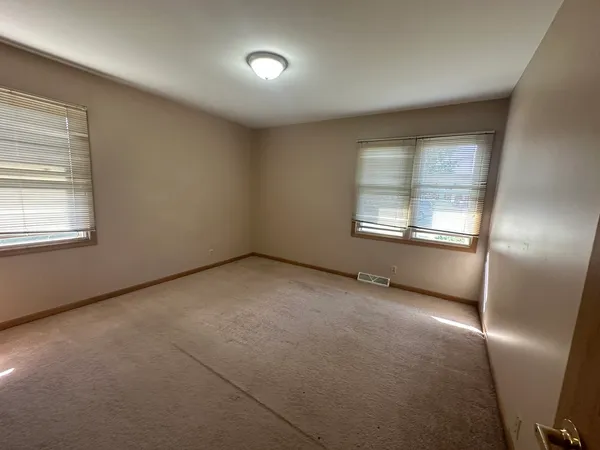 an empty room with windows and closet
