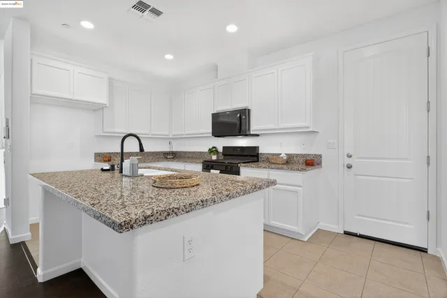 a kitchen with stainless steel appliances granite countertop a sink stove and cabinets