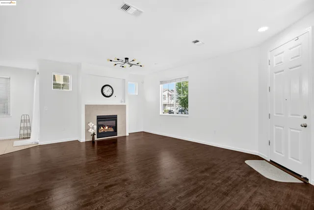 an empty room with windows and a fireplace