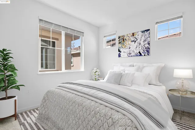 a bedroom with a large bed and a potted plant