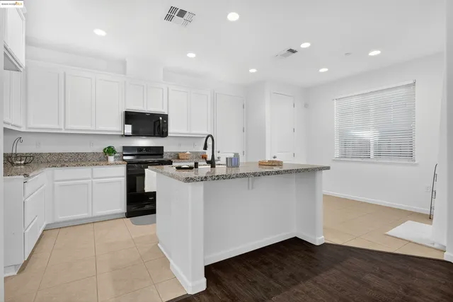 a kitchen with appliances a sink and cabinets