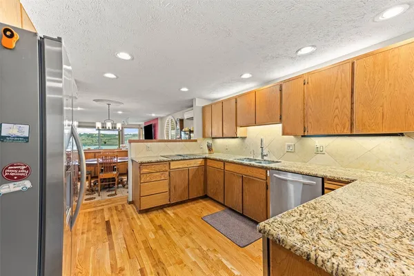 a kitchen with stainless steel appliances granite countertop wooden cabinets a sink and dishwasher