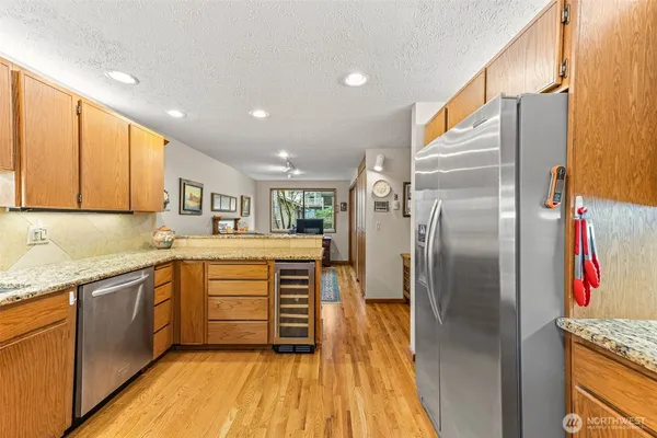 a kitchen with stainless steel appliances granite countertop a refrigerator and a sink