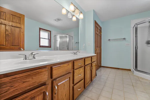 a spacious bathroom with double vanity and a mirror