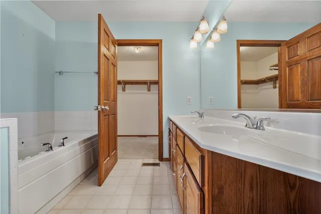 a bathroom with a tub sink and mirror