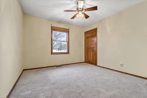 an empty room with windows and fan