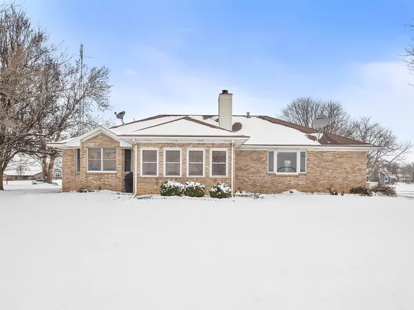 a front view of a house with a yard covered in snow